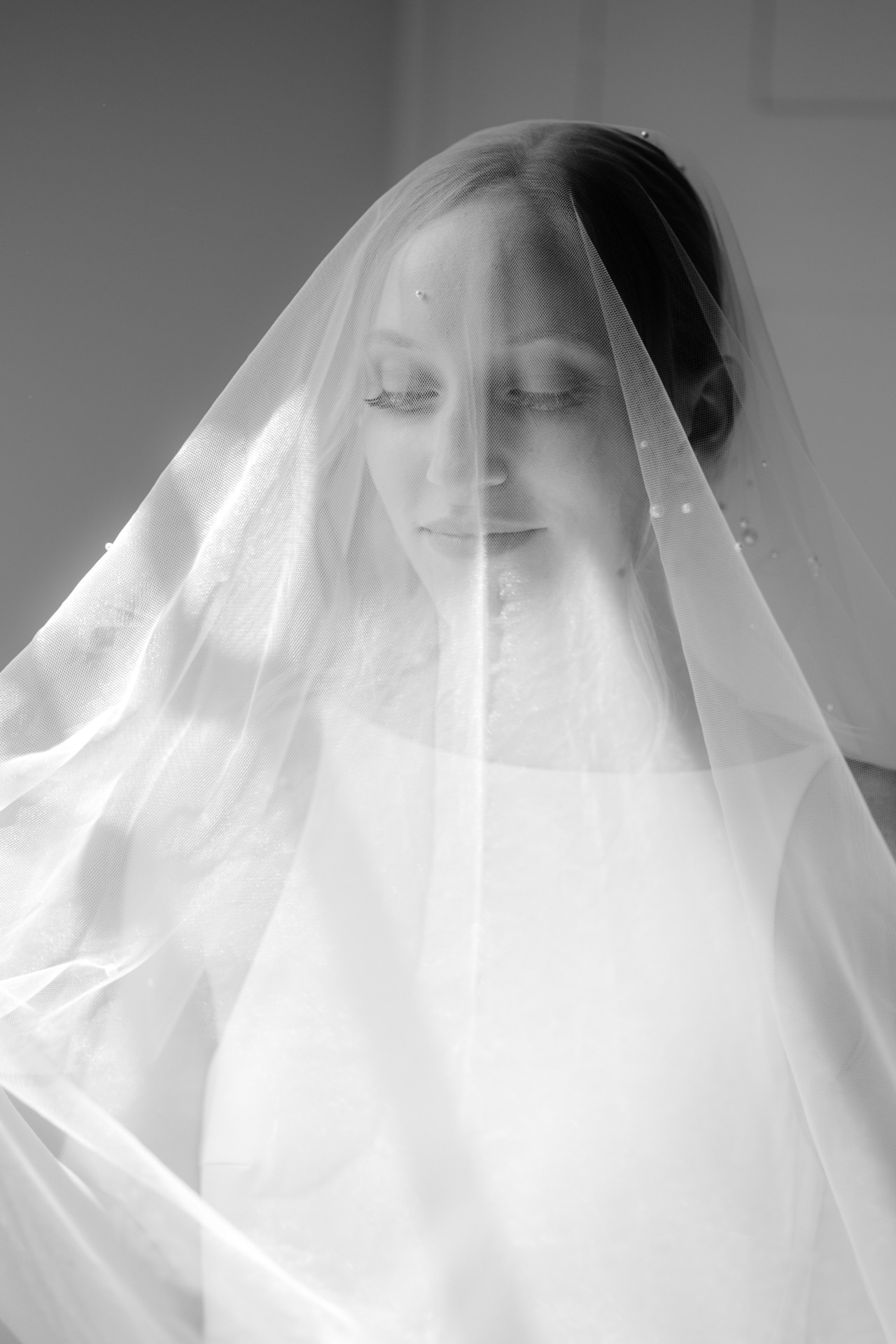 Bride covered in veil bw